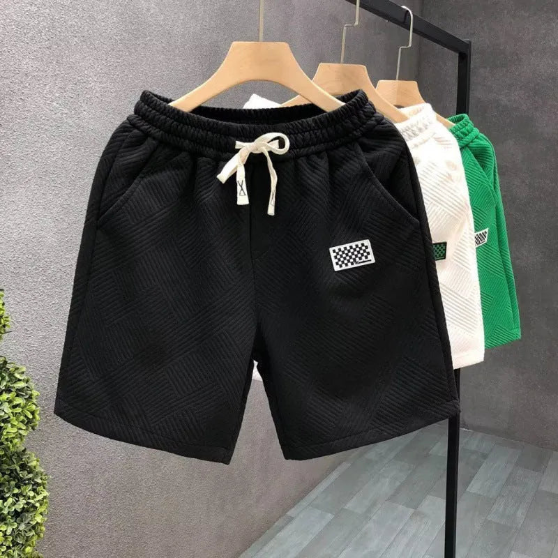 Men's solid colour polyester sports shorts with elastic waist in white, black and green options