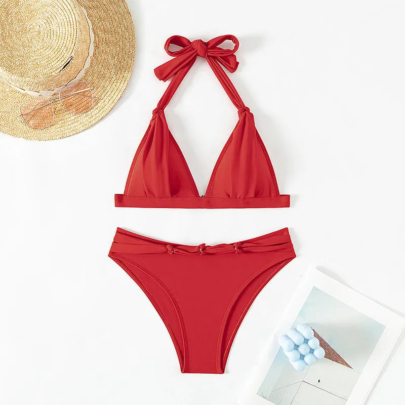Red women's lace-up halterneck bikini set with split shorts on a mannequin.