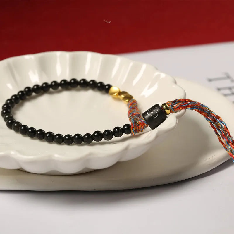 Hand-woven obsidian wrist bracelet showing 4mm width and textured strand construction