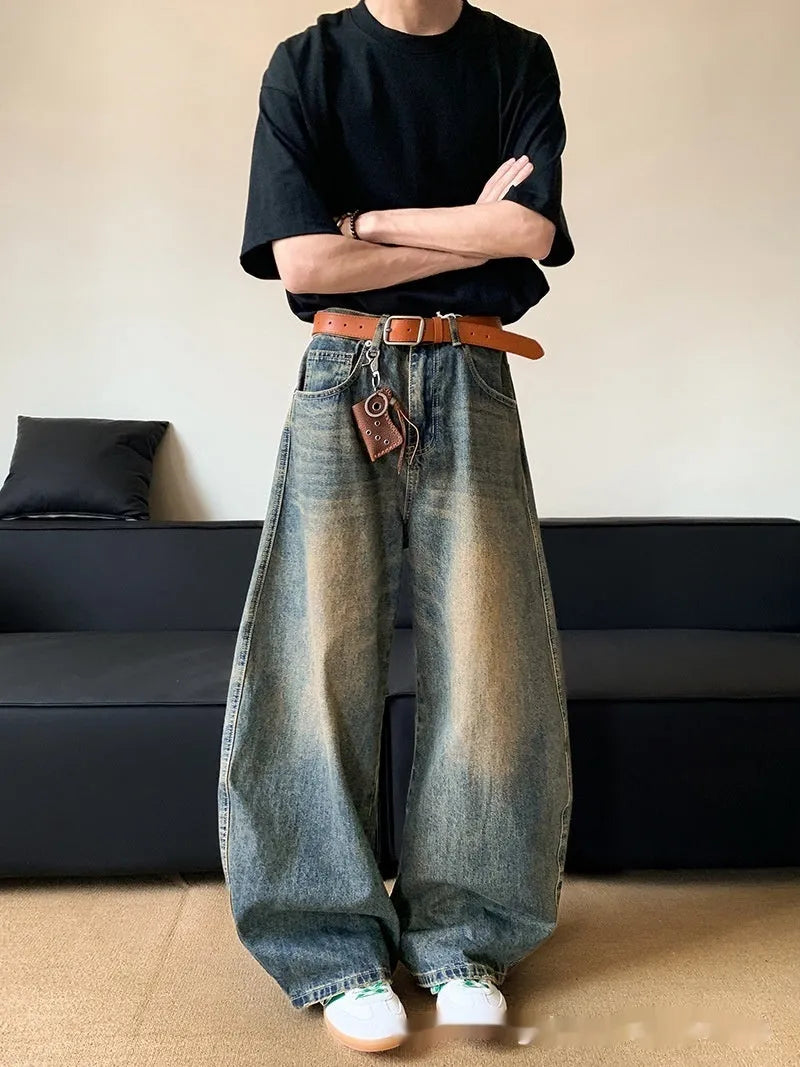 Men modelling retro blue distressed wide-leg jeans with machete detailing and a slimming fit.