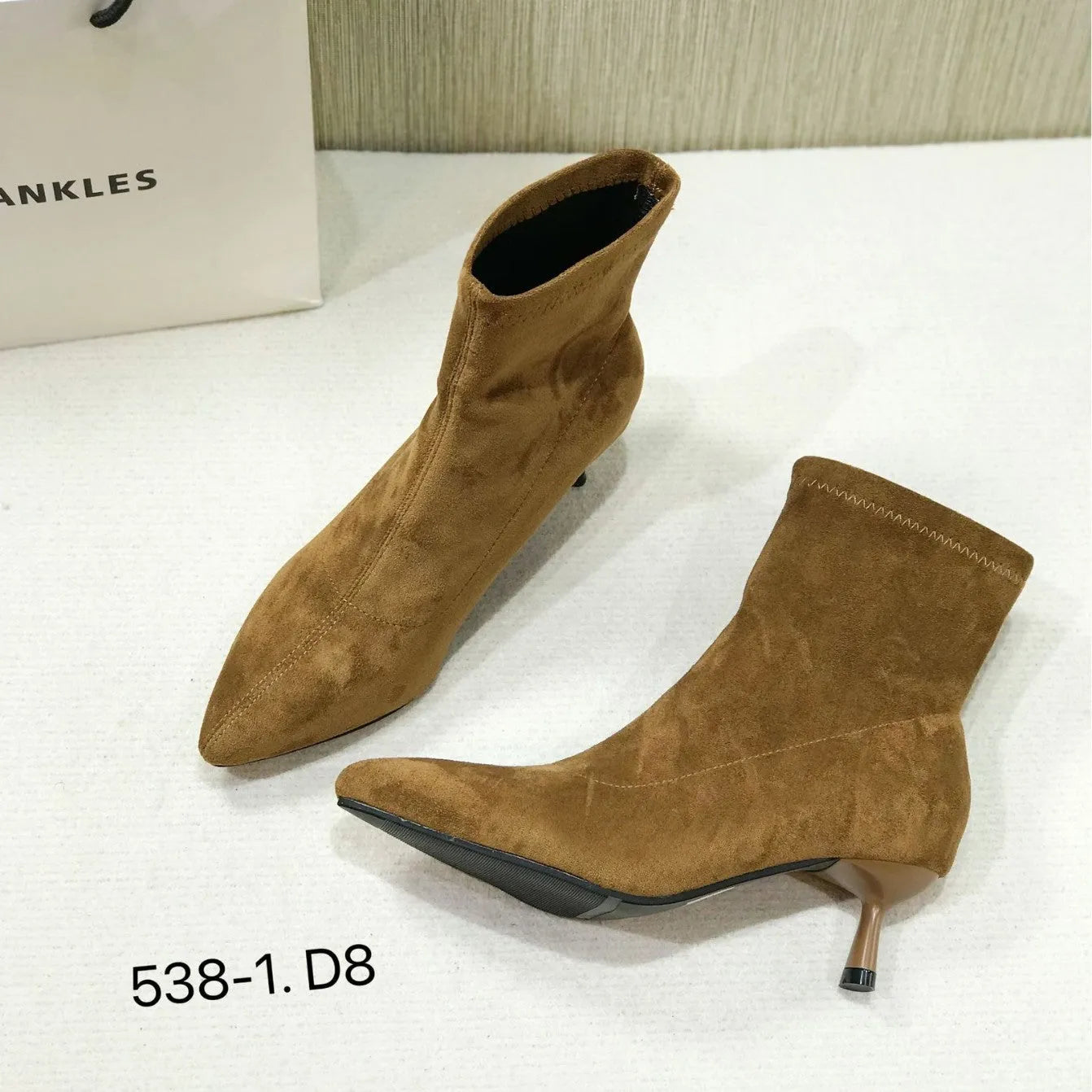 Women's black pointed toe ankle boots with stiletto heels and mid-calf length