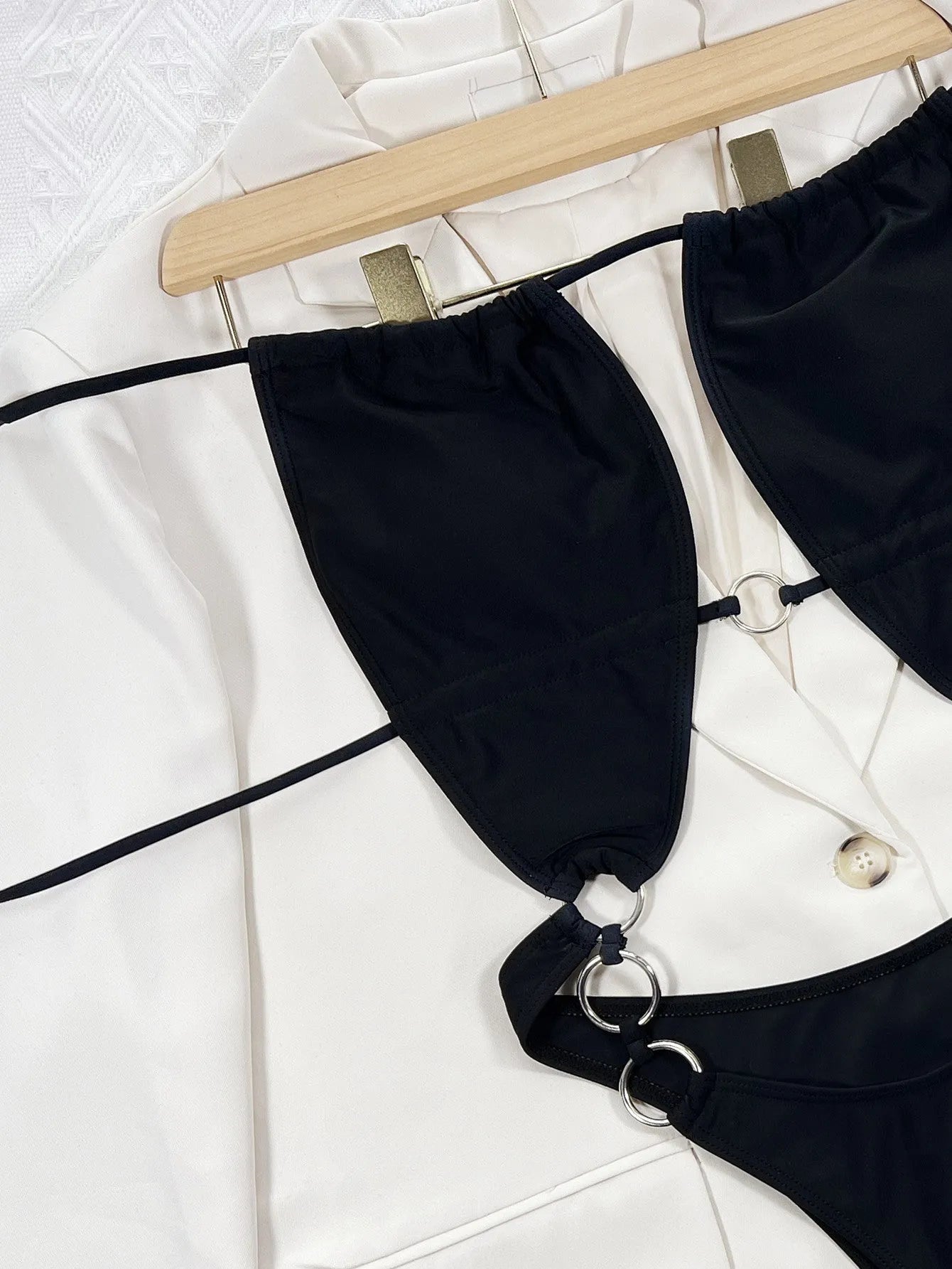 Black sleeveless one-piece swimsuit for women on a hanger.