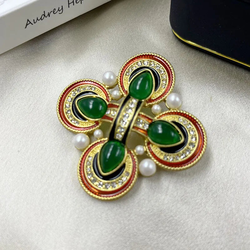Close-up of a metallic medieval baroque cross brooch with crystal details on a dark background