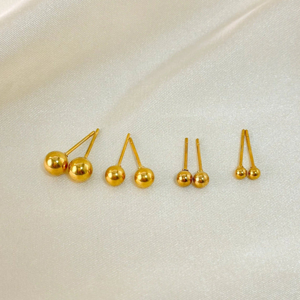 Stainless steel ball stud earrings with geometric design in gold or silver finish.