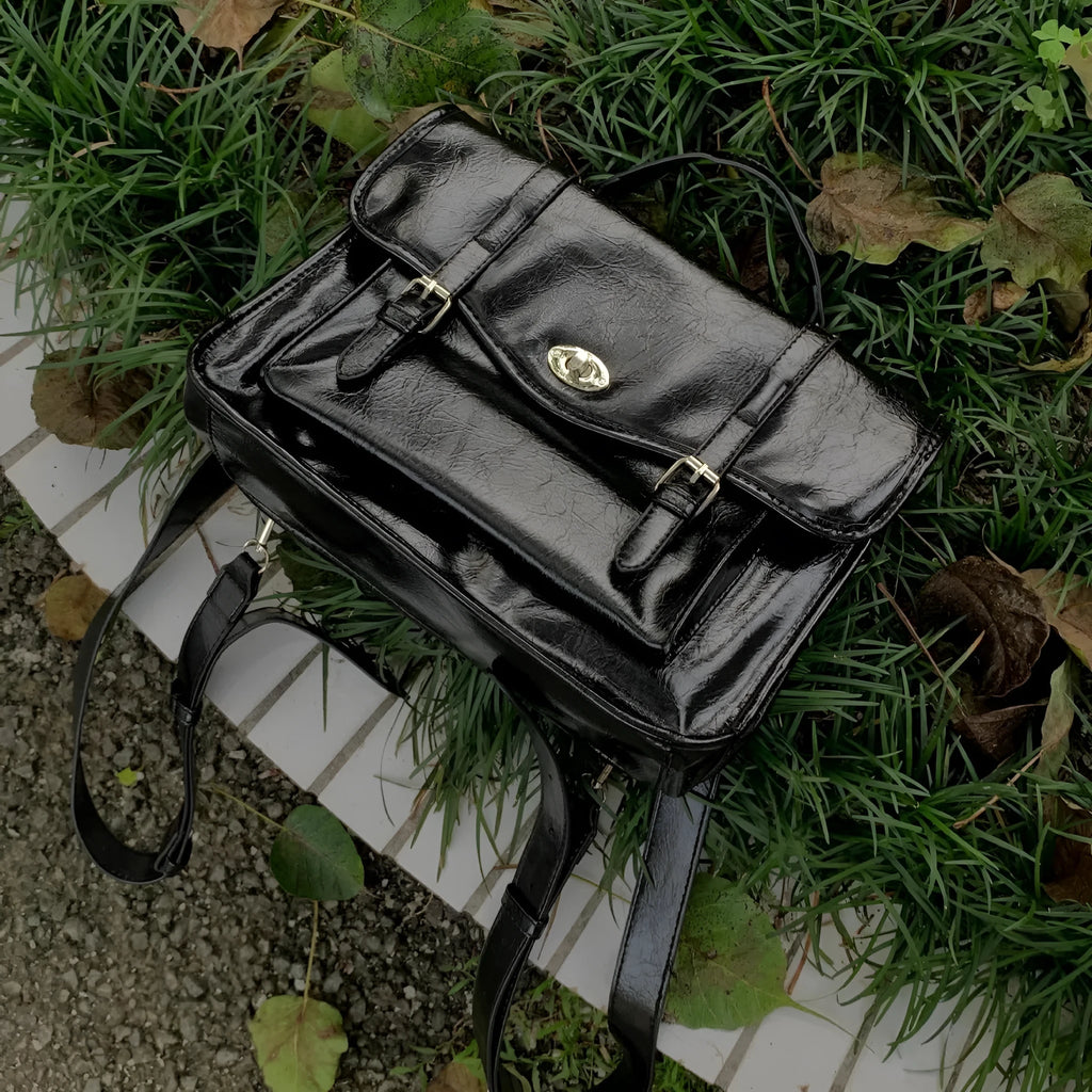 Black college messenger bag with oil wax leather finish showing compact 35cm dimensions