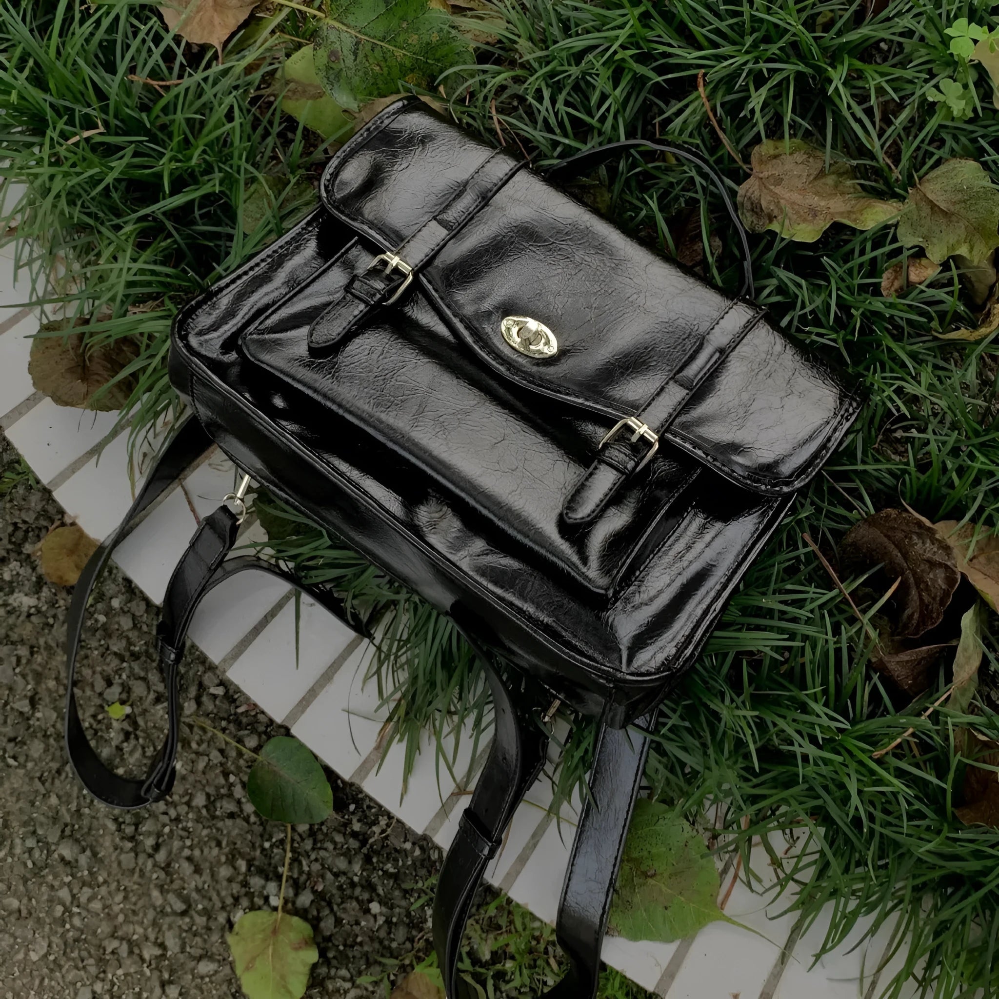 Black college messenger bag with oil wax leather finish showing compact 35cm dimensions