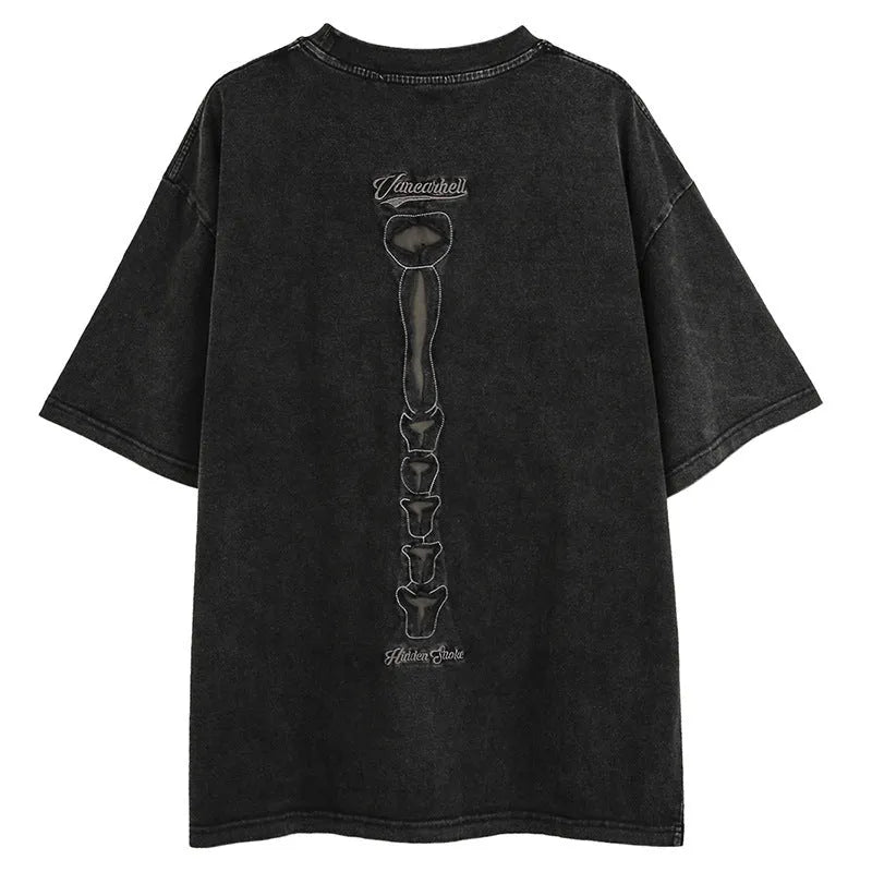 Man wearing a black loose-fit cotton T-shirt with a printed skull and letters graphic and drop-shoulder sleeves.
