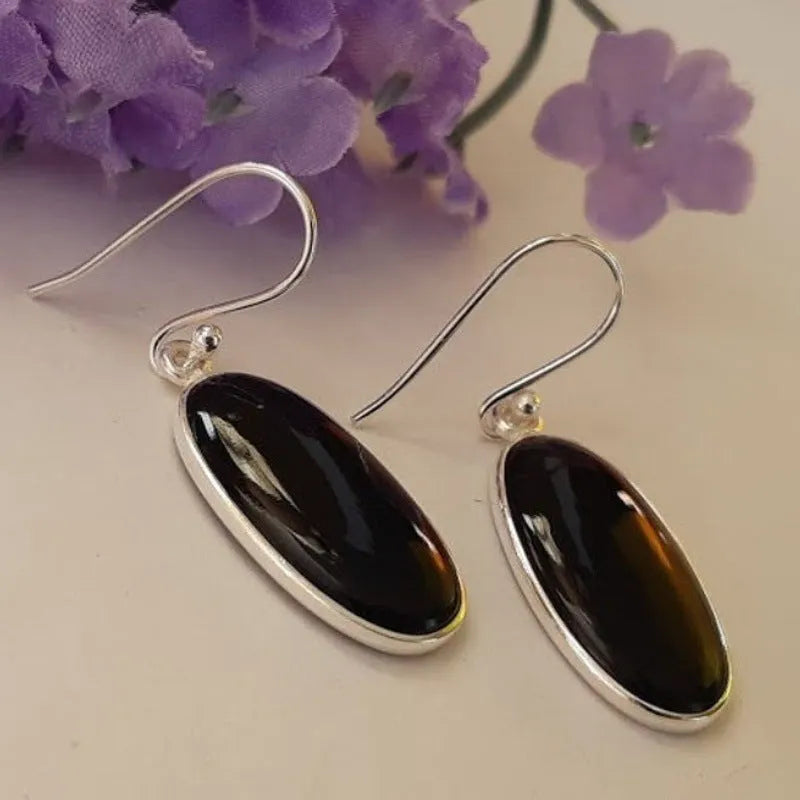 Women's earrings with black oval agate pendant and silver electroplated geometric Chinese style design.
