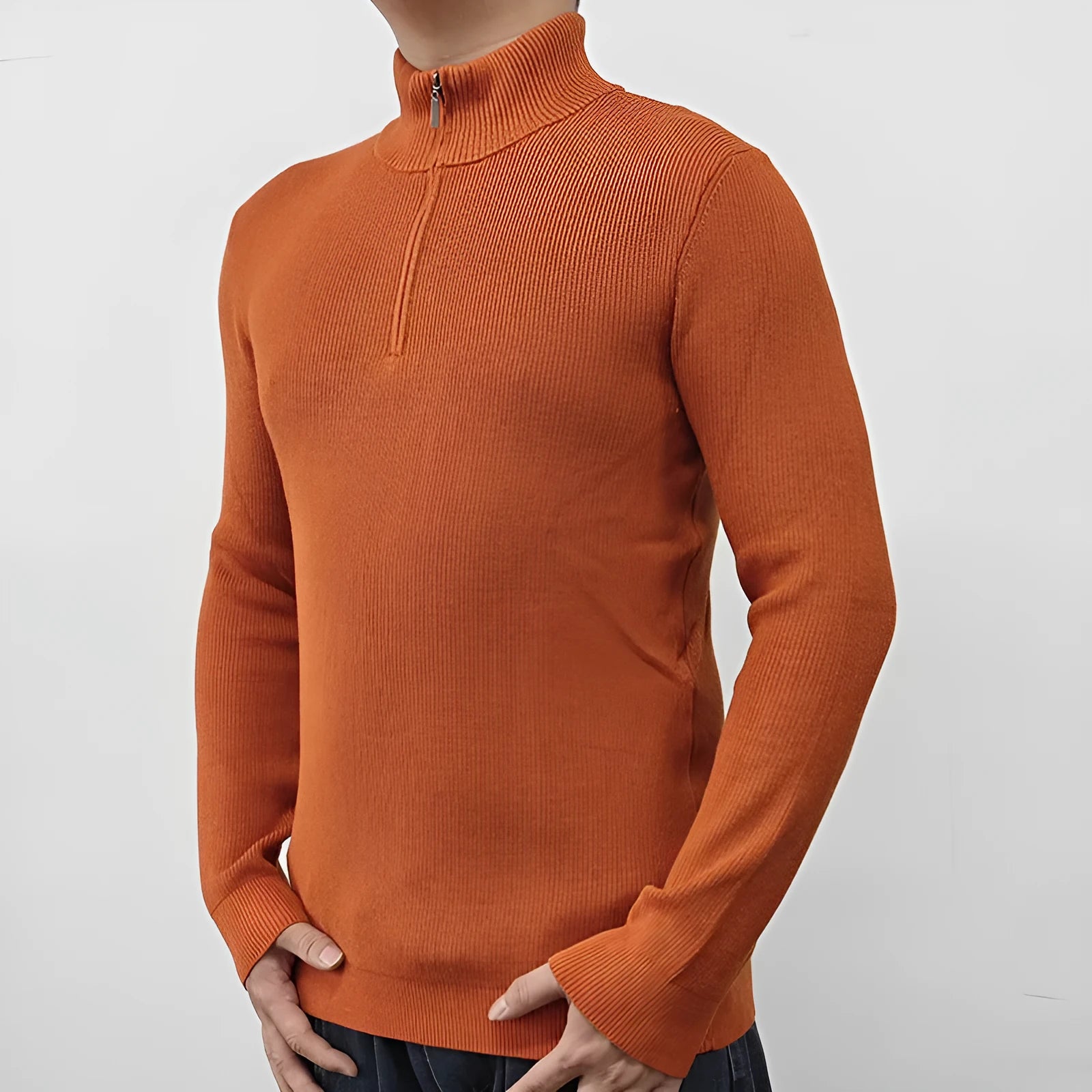 Man wearing a grey zip-up half-turtleneck sweater with long sleeves.