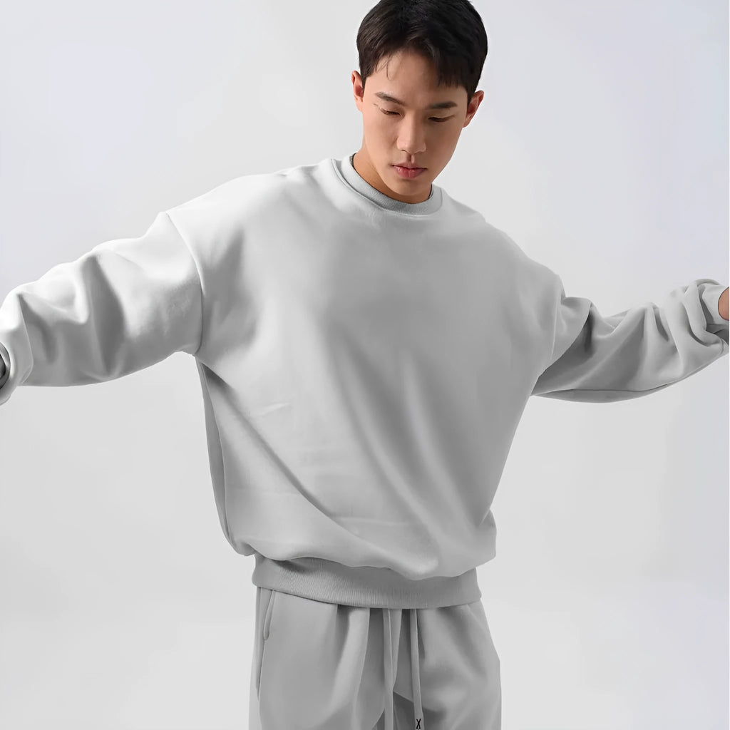 Men's loose-fit polar fleece sports suit in black, showing the long sleeve crew neck coat and matching padded trousers.