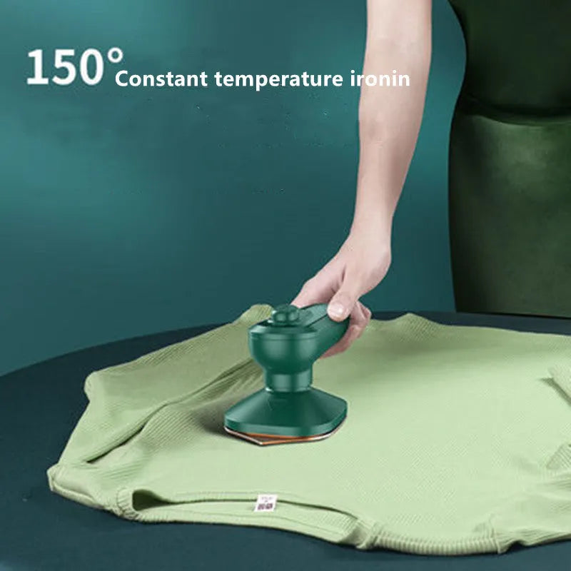 Dark green portable hanging steam iron machine with ceramic panel, shown for scale next to a mobile phone.