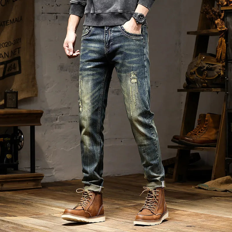 Men's skinny fit retro blue jeans with a high waist and zip fly on a plain background.