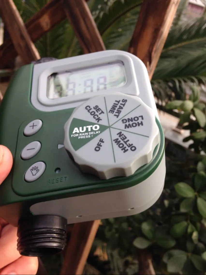 Green digital garden hose timer with large LCD screen and two outlet valves