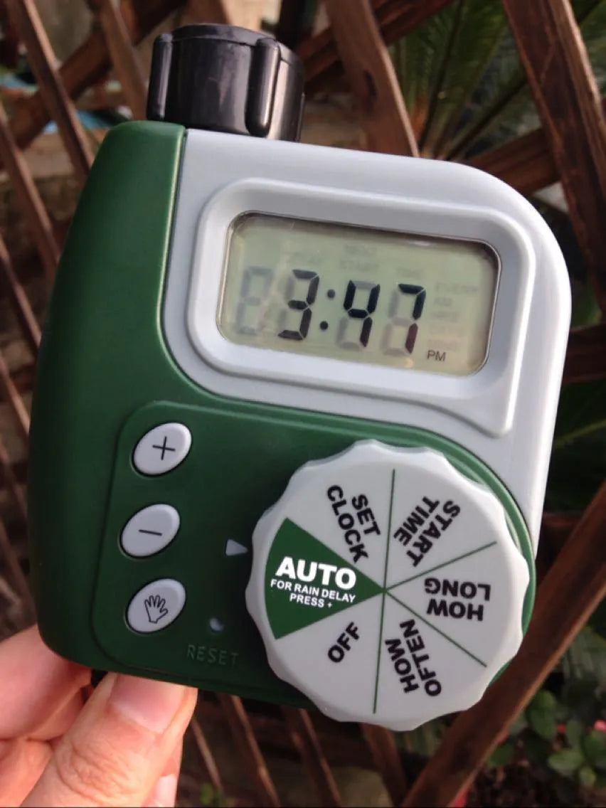 Green digital garden hose timer with large LCD screen and two outlet valves