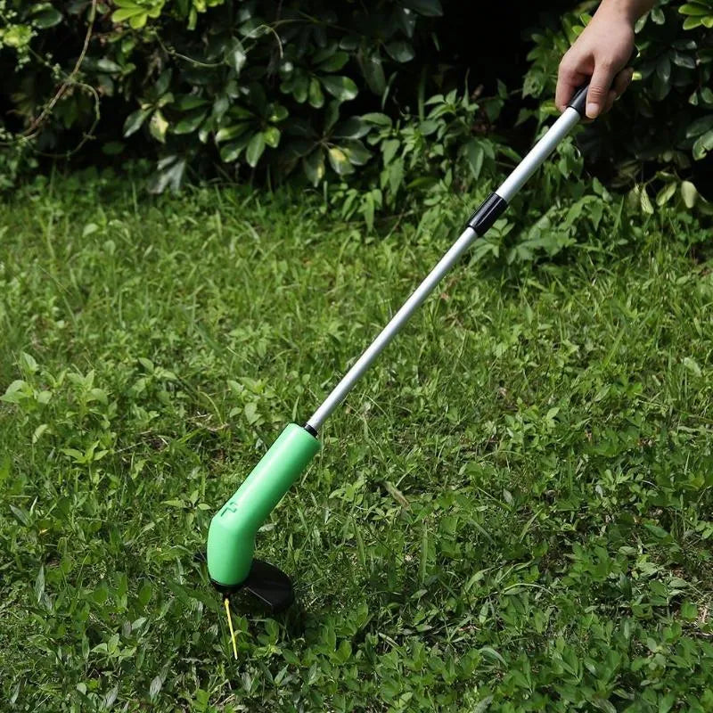 Cordless handheld lawn trimmer with extension pole and protective debris shield on a lawn.