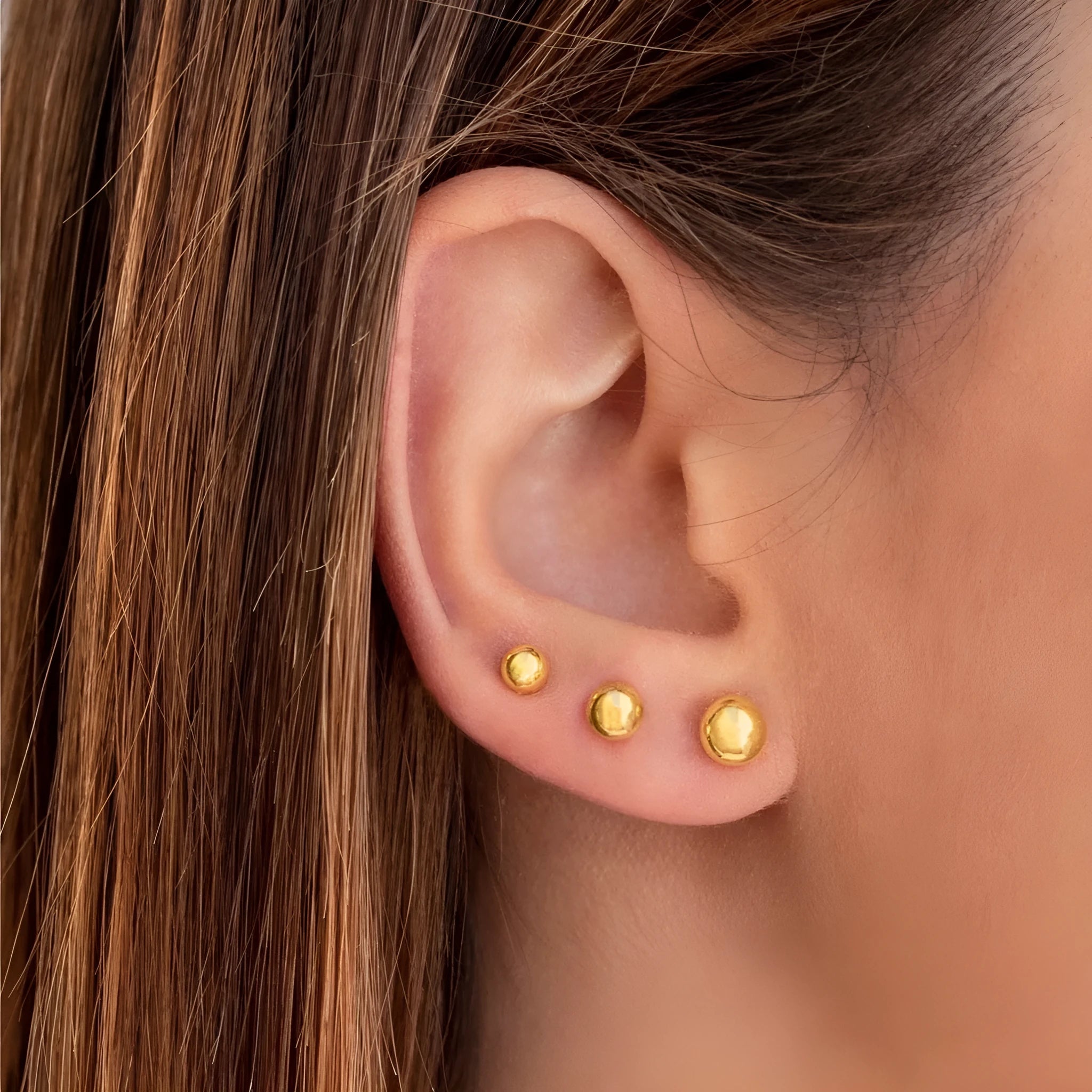 Stainless steel ball stud earrings with geometric design in gold or silver finish.
