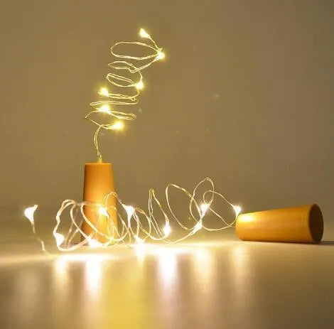 Flexible copper wire LED string lights wrapped around wine bottle with warm white illumination