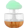 White cloud-shaped humidifier with coloured night light and mist output on a table