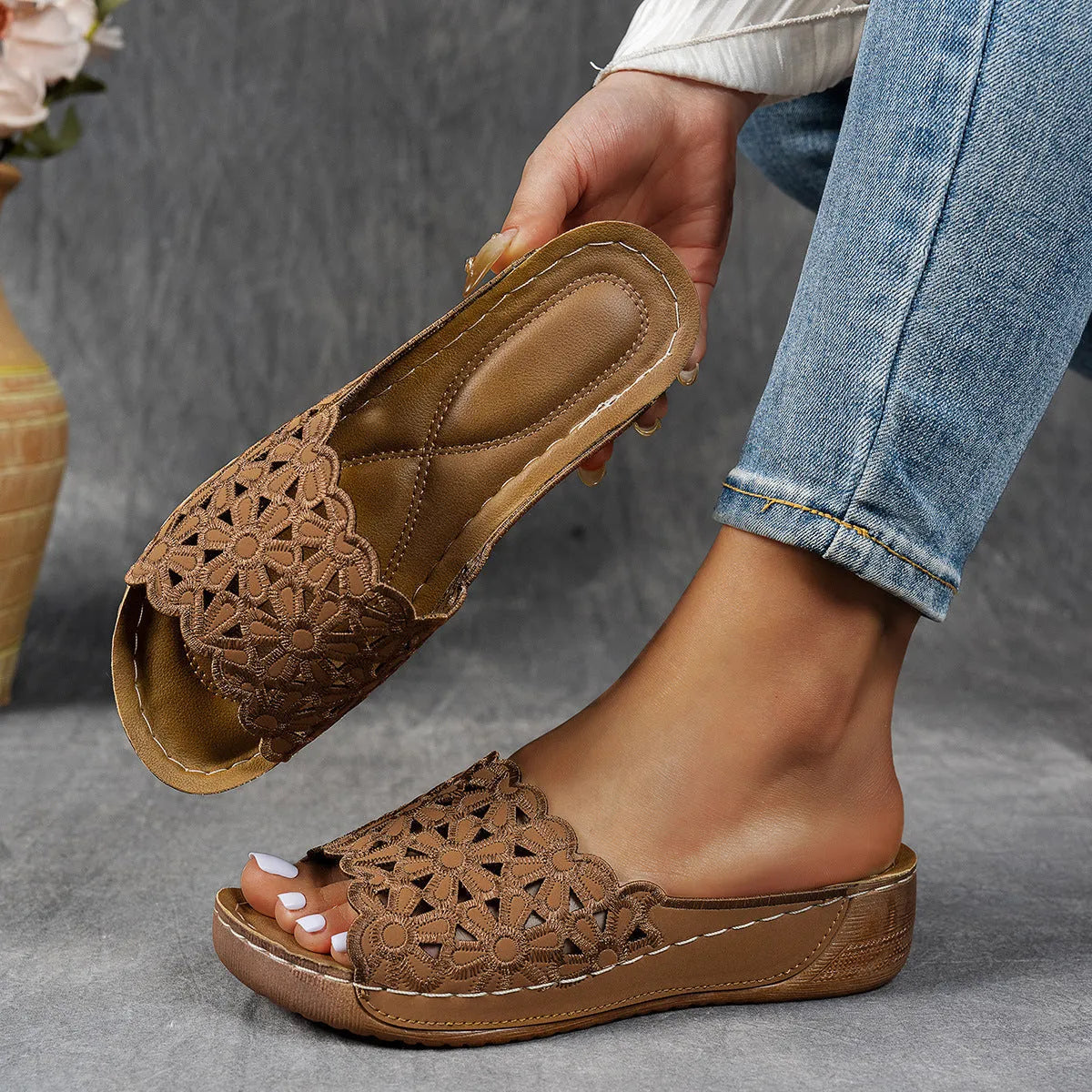 Black women's wedge beach sandals with a floral cutout pattern on the PVC upper.