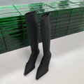 Black pointed toe women's boots with a back zipper and a stiletto heel.
