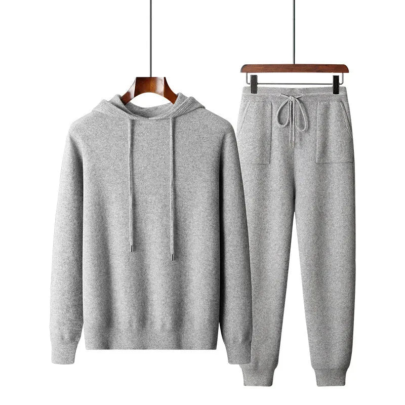 Men's light grey hooded cashmere sweatshirt and matching long pants laid flat as a complete casual winter set.