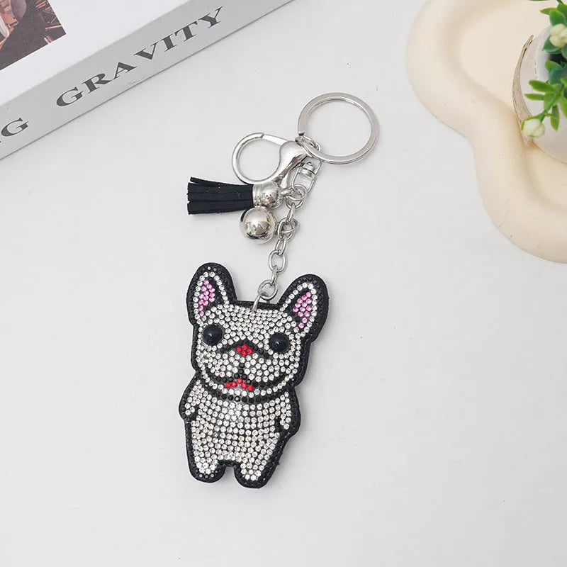 Close-up of a rhinestone and alloy French dog cartoon keychain with tassel pendant