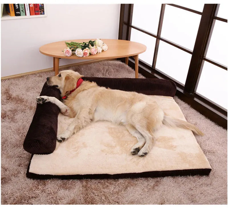 Corduroy pet sofa dog bed with bolster, shown in a grey colour on a wooden floor.