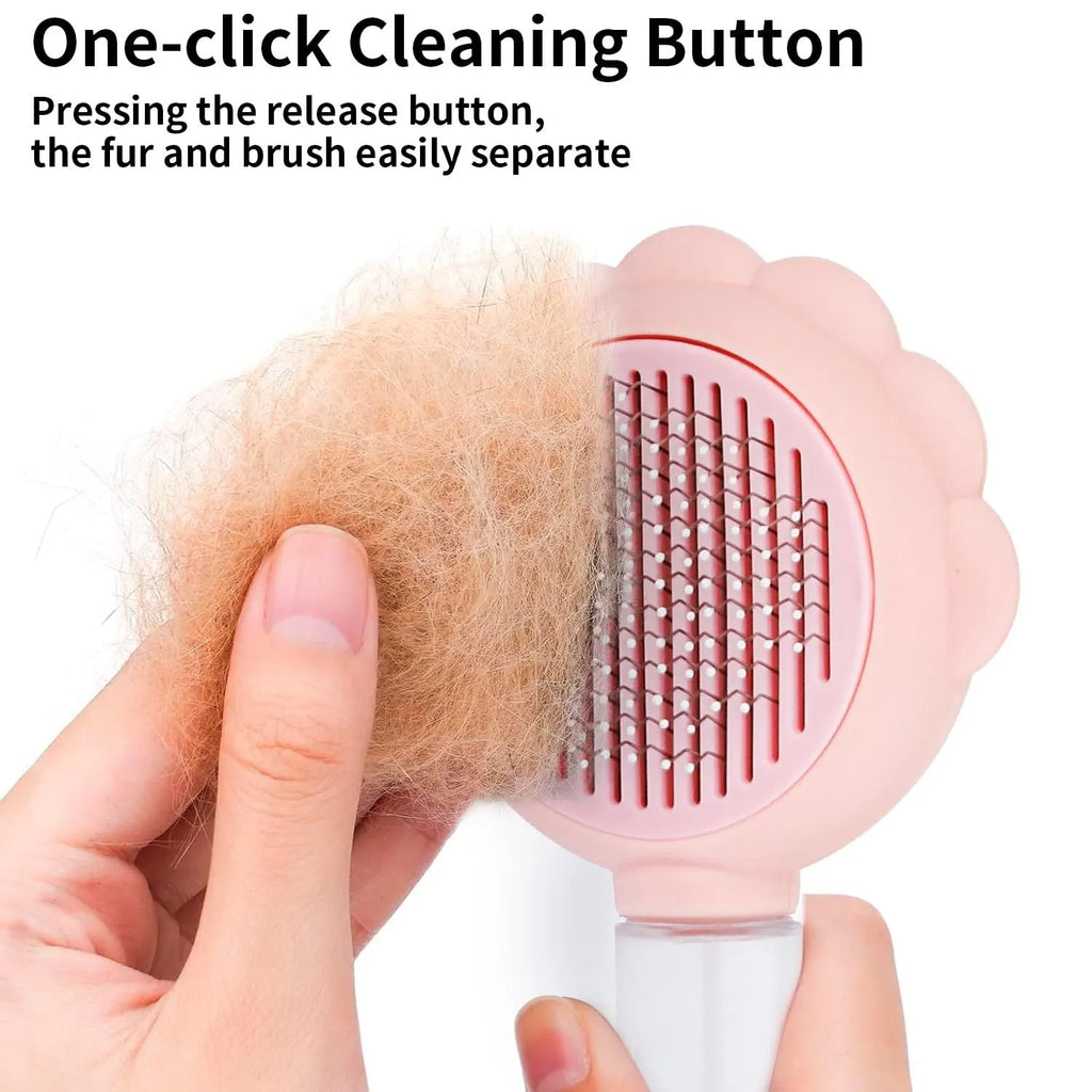 Grey spray cat grooming brush with a release button and stainless steel bristles on a wooden table.