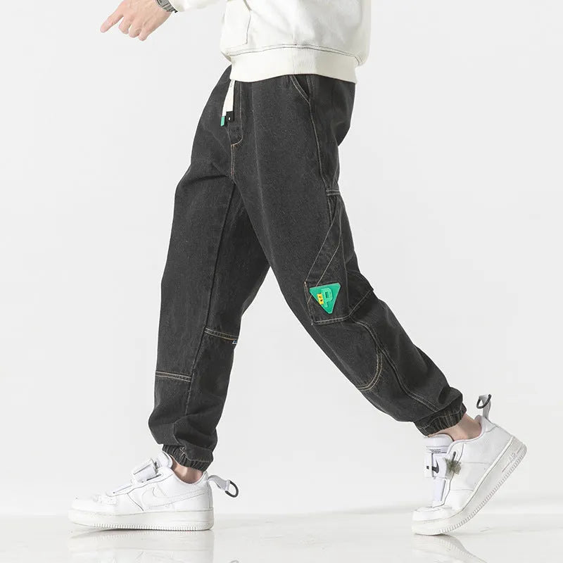 Men's loose-fit tapered cotton trousers in black, blue, or grey on a mid-waist.
