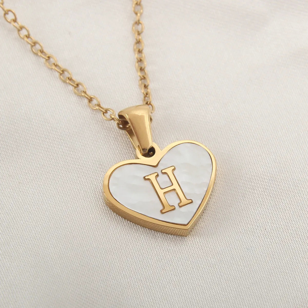 Gold plated initial necklace with white shell heart pendant and adjustable chain