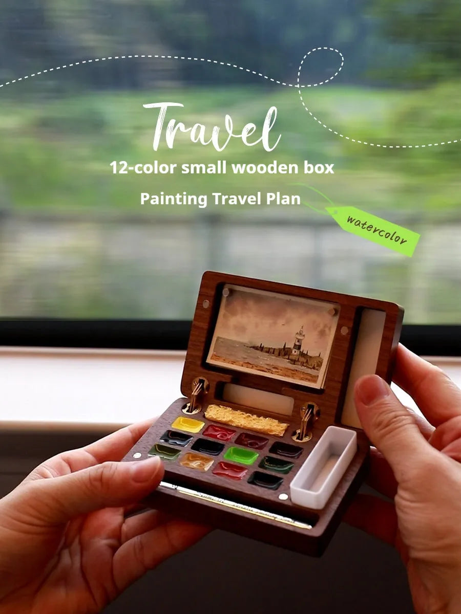 Mini wooden watercolour paint box open to show pigment pans inside.