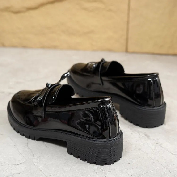 Women's brown artificial PU loafers with a black bow decoration on the vamp, shown on a white background.