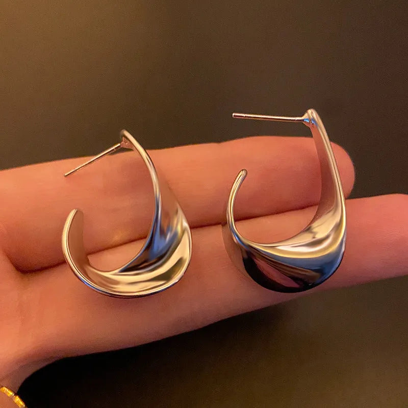 Geometric twisted metal earrings with round elements in gold or silver electroplated finish