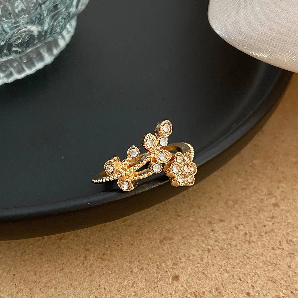 Copper open ring with diamond-treated floral and leaf decoration in gold colour