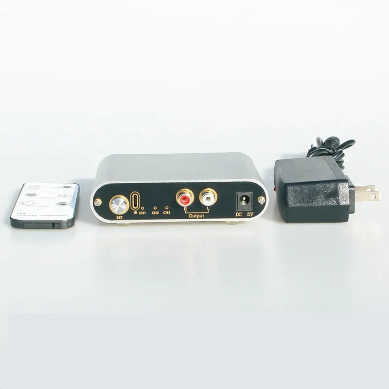 Silver aluminium audio source switch box with remote control for input/output selection.