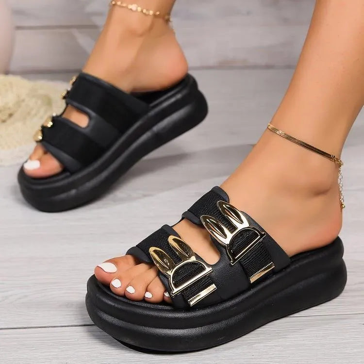 Women's apricot suede slippers with a thick rubber sole on a wooden floor.