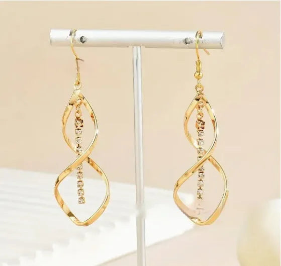 Women's gold geometric spiral earrings with ellipse diamond elements on alloy construction