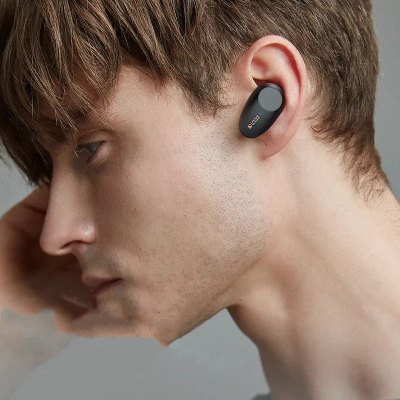 Black wireless Bluetooth headset with charging stand showing earbuds.
