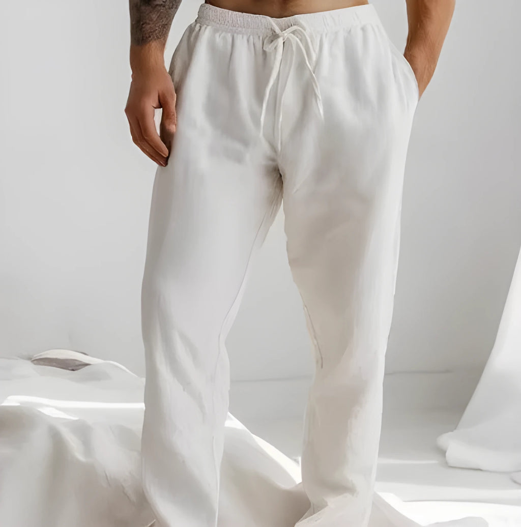 Man wearing light blue loose-fit cotton linen trousers with an elastic drawstring waist.