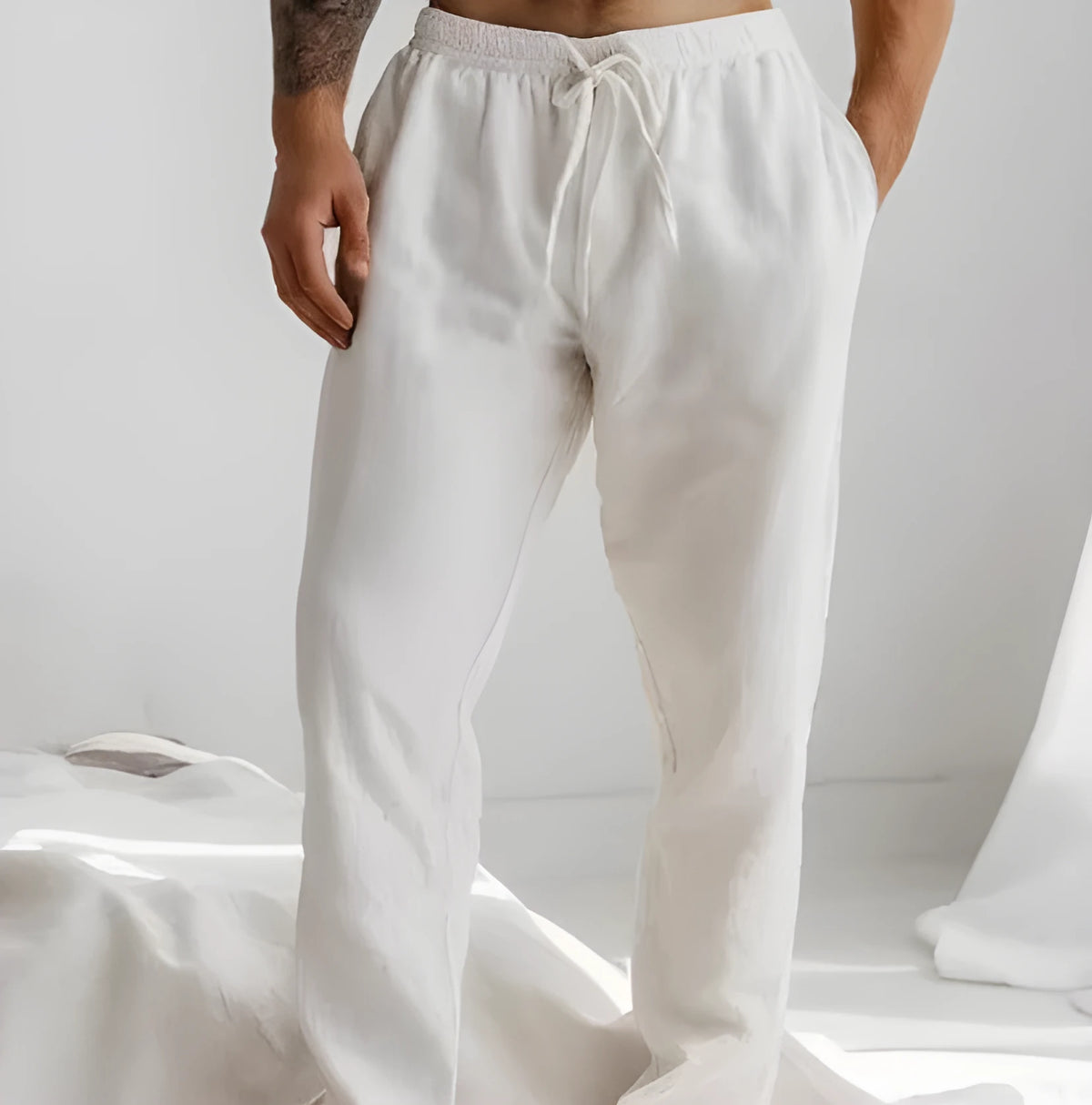 Man wearing light blue loose-fit cotton linen trousers with an elastic drawstring waist.