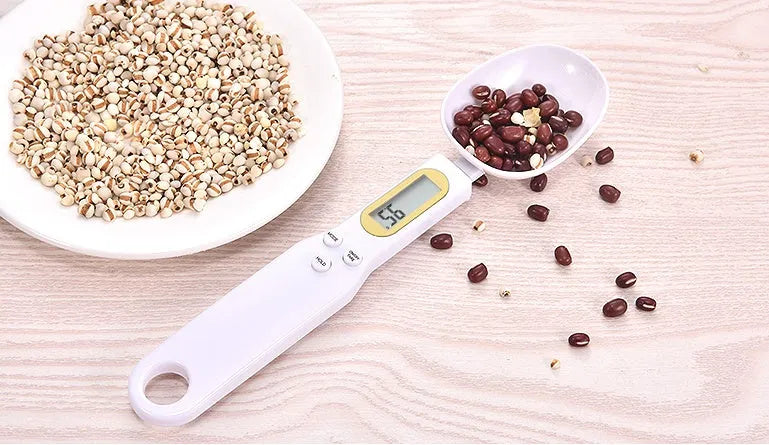 Black digital measuring spoon scale showing weight on display, with spoon bowl for holding materials.