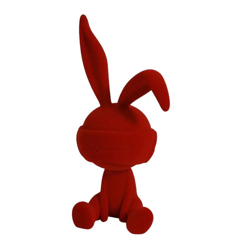Green suede blindfold rabbit resin table ornament on a wooden desk