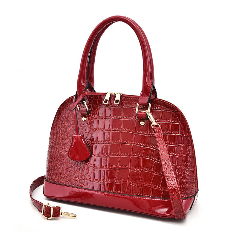 Shiny PU leather crossbody bag in shell shape design showing black, red and brown colour options