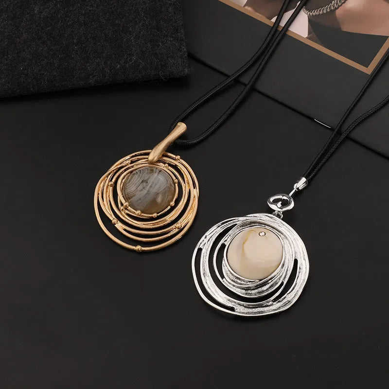 Gold geometric plaid pendant on a snakeskin-textured chain, adjustable sweater necklace.