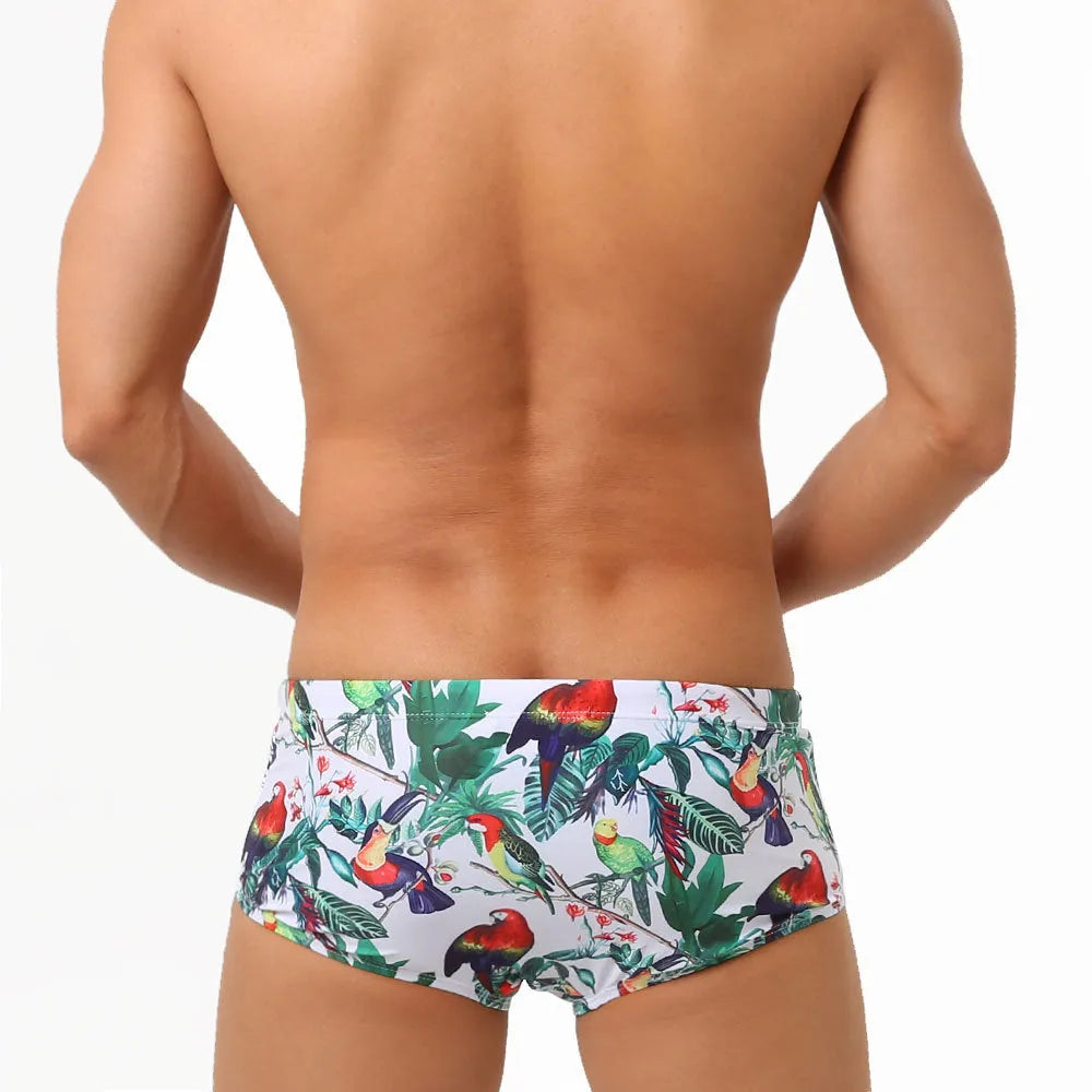 Men's navy swim trunks with colourful flower and bird print pattern, boxer style