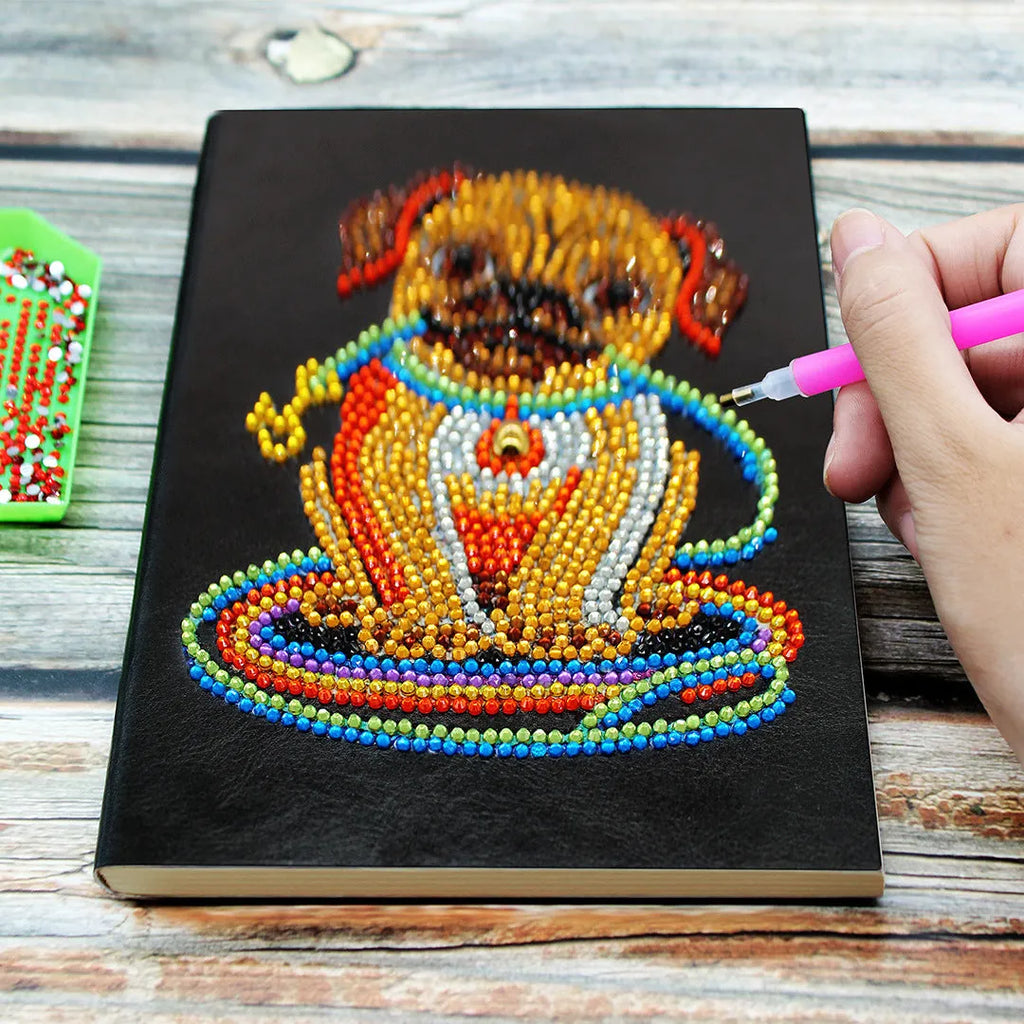 Black hardcover A5 diamond painting notebook with 50 cream pages open on craft table