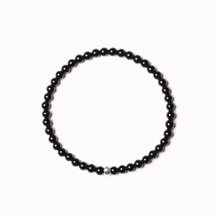 Geometric stone bracelet with obsidian, blue san, and black agate 4mm beads on a wrist.