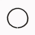 Geometric stone bracelet with obsidian, blue san, and black agate 4mm beads on a wrist.