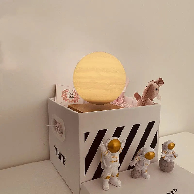 Maglev Moon Earth planet night light floating above base with LED glow, next to astronaut figurines.