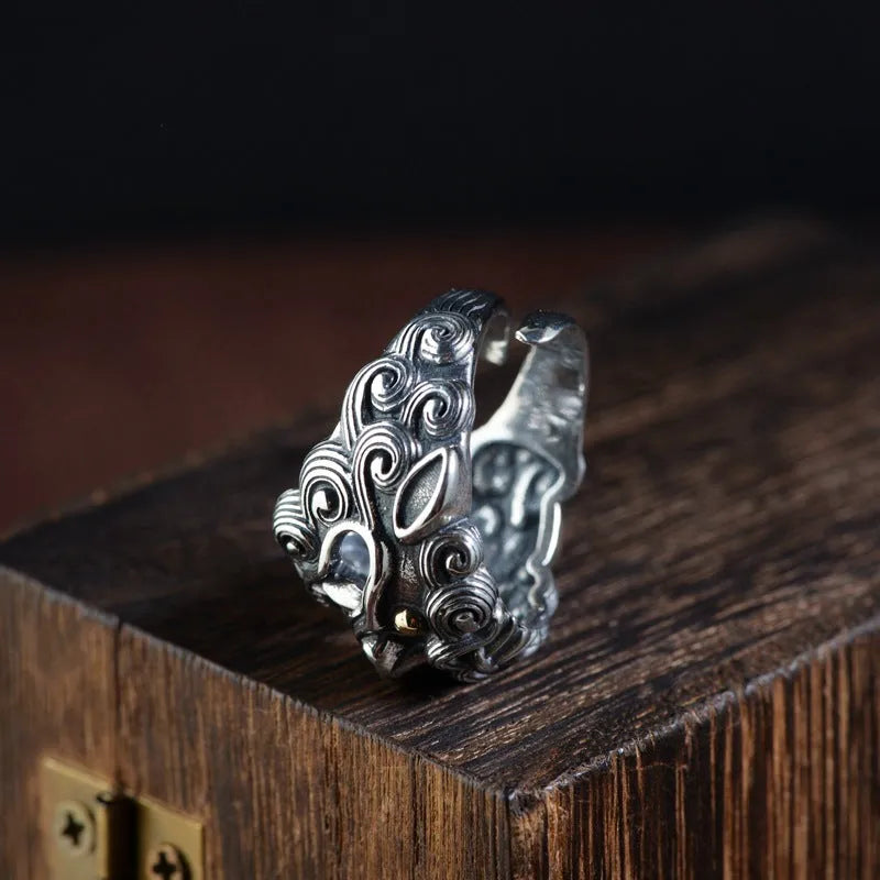 Detailed silver open ring featuring an animal zodiac beast pattern on a model's finger.